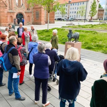 Gruppe bei einer Führung des Märchenerzählkreis vor der Skulpur Rotkäppchen